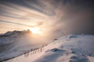 sneeuwheuvel met zonsopgang op bergketen foto