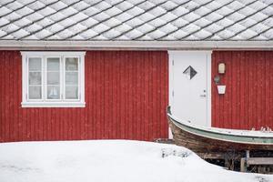 rode Noorse residentie met houten boot op winter foto