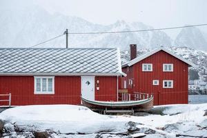 houten rood huis van vissersdorp in besneeuwde winter op de Lofoten-eilanden foto