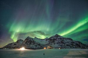 aurora borealis, noorderlicht over sneeuwbergketen in skagsanden-strand bij lofoten-eilanden foto