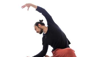 jonge blanke langharige blanke man voert yoga uit in een studio of huis. foto