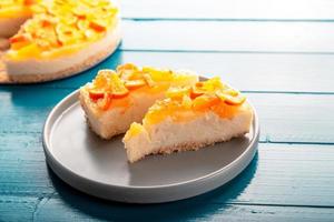 close-up detailweergave gesneden sinaasappel cheesecake of pudding, versierd met gerijpte sinaasappel fruit. foto