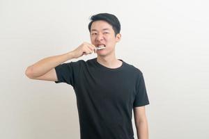 portret jonge aziatische man tanden poetsen foto