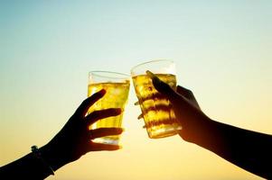 rinkelen een glas bier close-up van een glas koud bier aan zee ze tweeën vrolijk glimmend in de zon tijdens het happy hour van de bierdrinker om de feestdagen en het feest door te brengen. foto