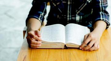 man zittend in vintage stoel voor zijn huis op een rustdag een boek lezen en ontspannen. wazige achtergrond. horizontaal filmeffect. het concept van het lezen van boeken om zelfkennis te vergroten. foto