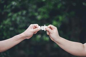 de hand die de puzzel oppakt en samenvoegt. eenheid foto