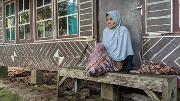 16 maart 2022 in het regentschap Cianjur, West-Java, Indonesië. een oude grootmoeder zat op de veranda van haar huis. foto