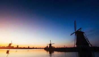 kleurrijke lente zonsondergang traditionele Nederlandse windmolens kanaal in rott foto