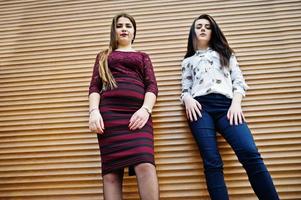 twee jonge tieners meisje gesteld tegen oranje sluiter. mollig meisje vs dun. foto