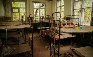 oude roestige sovjetbedden in de kleuterschool in de spookstad Tsjernobyl, oekraïne. foto