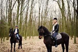 jonge stijlvolle paar rijden op paarden in herfst bos. foto