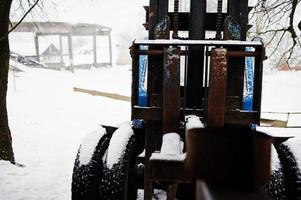 roestige oude Sovjet-tractor bedekt met sneeuw. foto
