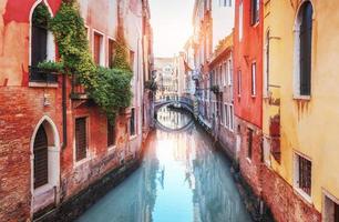 traditionele gondels op smal kanaal tussen kleurrijke historische huizen in Venetië, Italië foto