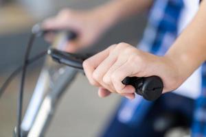 jongenshand die een fietsrem houden. kind zittend op een fiets met de handrem foto