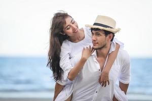 gelukkige romantische koppels minnaar hand in hand samen wandelen op het strand foto