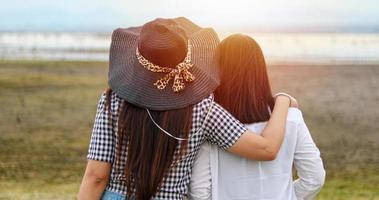 aziatische jonge vrouwen hebben 's avonds plezier en lachen en knuffelen op het groene veld. foto