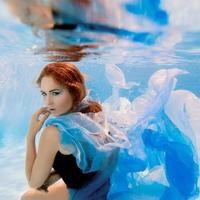 onderwater mode portret van mooie jonge vrouw in blauwe jurk foto
