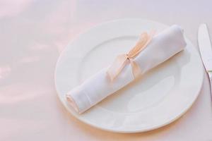 wit servet op het bord op tafel. bestek, eten, lunch, feestconcept foto