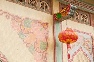 traditionele eenvoudige draak schilderij standbeeld met rode chinese lantaarn hangend in aziatische tempel foto