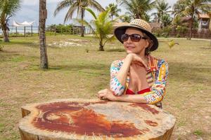 dame zit in een klein park in de buurt van het strand in Caraiva Bahia, Brazilië foto