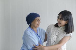kankerpatiëntvrouw met hoofddoek en haar ondersteunende dochter in ziekenhuis-, gezondheids- en verzekeringsconcept. foto