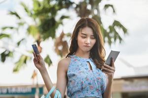 Aziatische jonge vrouw winkelen betalen met creditcard. foto