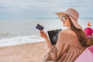 vrouw gebruikt creditcard op het strand tijdens vakanties foto