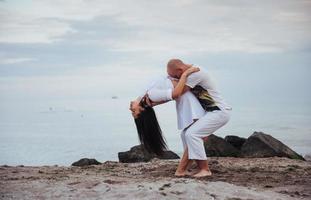 verliefde paar dansen op het strand aan zee in de zomer foto