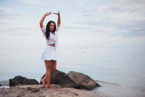 vrouw in een wit overhemd en een rok die op blote voeten danst foto