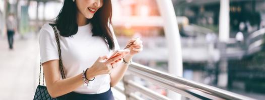 creditcard en smartphone vasthouden door volwassen vrouw om online te winkelen. foto