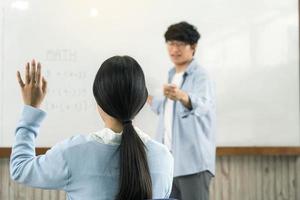 Aziatische mannelijke leraar die studenten lesgeeft in de klas foto