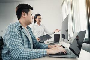 twee aziatische teamontwikkeling van programmeer- en encryptietechnologie website-ontwerpprogrammeurs op bureau in kantoor. foto