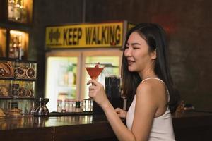 aziatische vrouwen die cocktails drinken en 's nachts plezier hebben aan de bar. foto