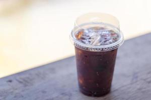 glas iced americano koffie op houten tafel foto