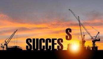 silhouet van succes op bouwwerf met kraan en zonsonderganghemel voor voorbereidingsbedrijfsconcepten foto