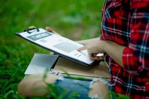 hand van personeel, marketingmanager die naar zakelijke documenten wijst en onder de boom zit - zakelijke ideeën foto