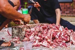 Indonesische moslims hakken vlees op de islamitische dag van eid al-adha foto