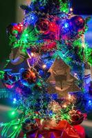 close-up tot kerstboom schijnt met blauwe, groene en rode lichten. foto