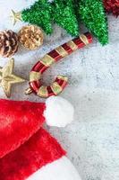 Kerst achtergrond in bovenaanzicht met snoepgoed, dennenappels, glitter ster en kerstman hoed. foto