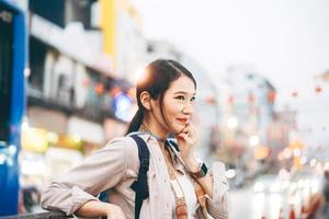 jonge volwassen Aziatische vrouw reiziger rugzak reizen in de stad levensstijl chinatown straatvoedsel met bokeh achtergrond. foto