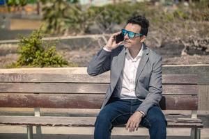 stijlvolle zakenman praten op smartphone op straat foto