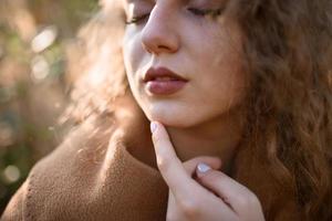 mooie elegante vrouw die in de herfst in een park staat foto