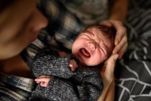 moeder houdt haar pasgeboren zoon in haar armen. foto