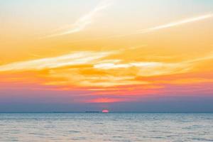 tropische kleurrijke zonsondergang over oceaan op het strand. op thailand toerisme achtergrond met zee strand. vakantie reis bestemming foto