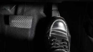 accelereren en remmen. voet indrukken voetpedaal van een auto om vooruit te rijden. foto