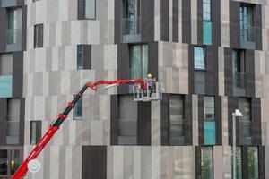 milaan italië 2021 bouwvakker op een hoogwerker aan de zijkant van een gebouw foto