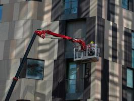 milaan italië 8 september 2020 bouwvakker op een hoogwerker aan de zijkant van een gebouw foto