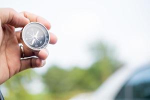 man hand met kompas op stad en auto wazig achtergrond met behulp van behang of achtergrond reizen of navigator afbeelding. foto