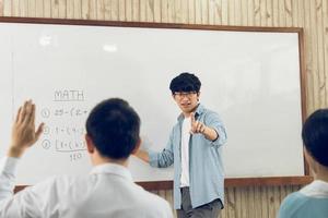 Aziatische mannelijke leraar die studenten lesgeeft in de klas foto