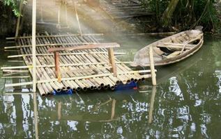 oude houten roeiboot afgemeerd aan de rand van een meer foto